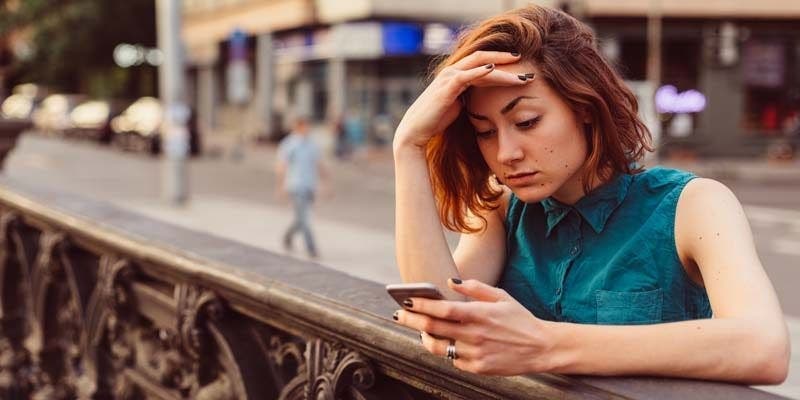 stressed woman looking at her phone